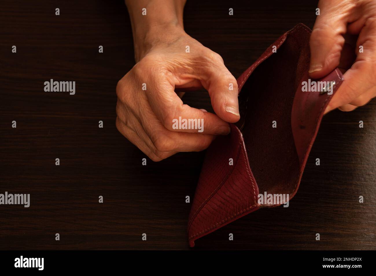 old woman's hands opened their empty wallet on the background Stock Photo