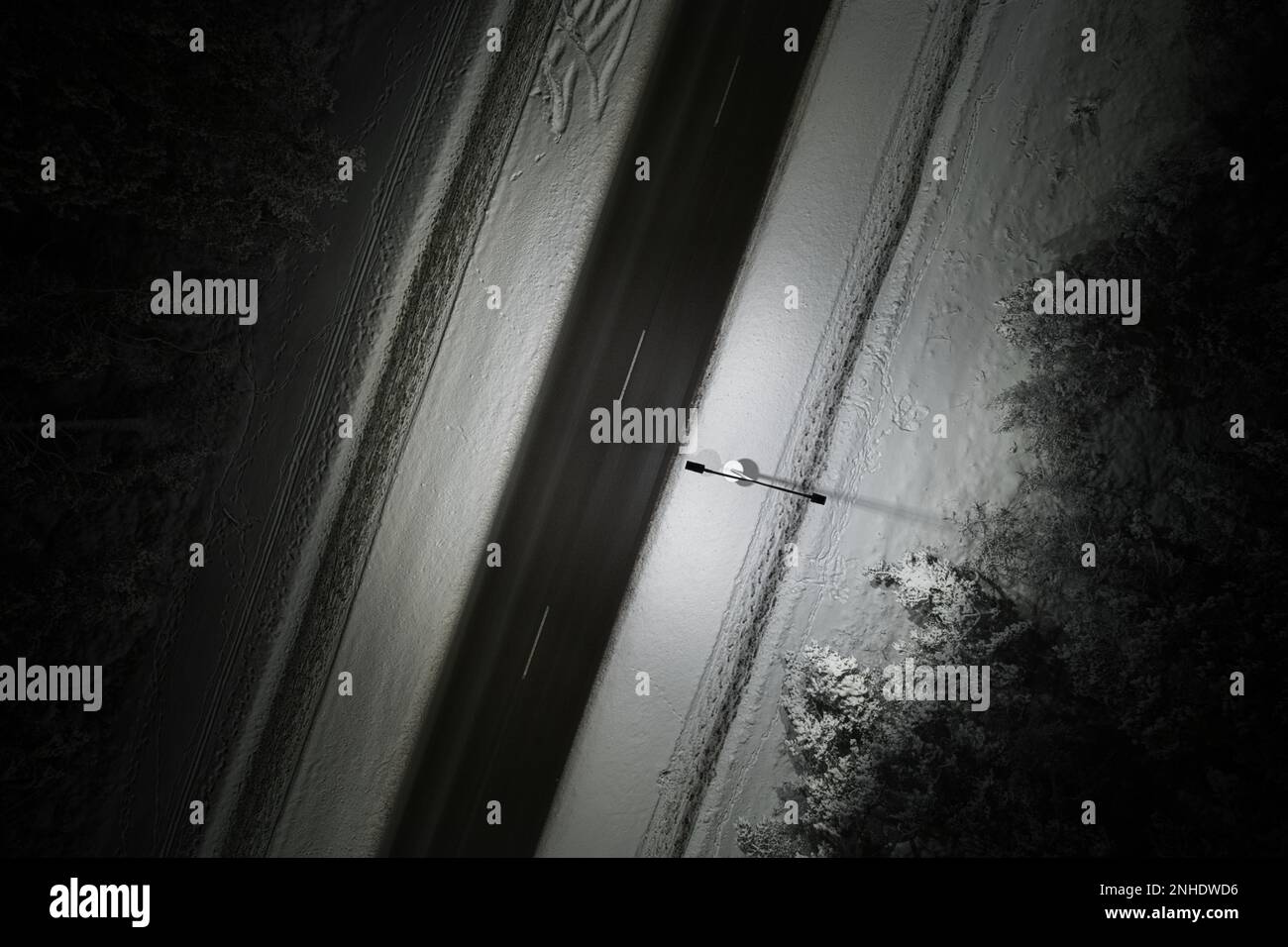 An atmospheric drone photo of a winter road winding through a snow ...