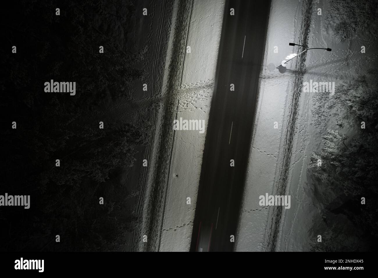 An atmospheric drone photo of a winter road winding through a snow ...