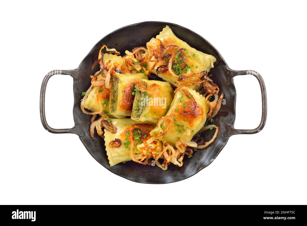 Fried Swabian meat ravioli (so called Maultaschen) with roasted onions, served in an iron frying pan on white background Stock Photo