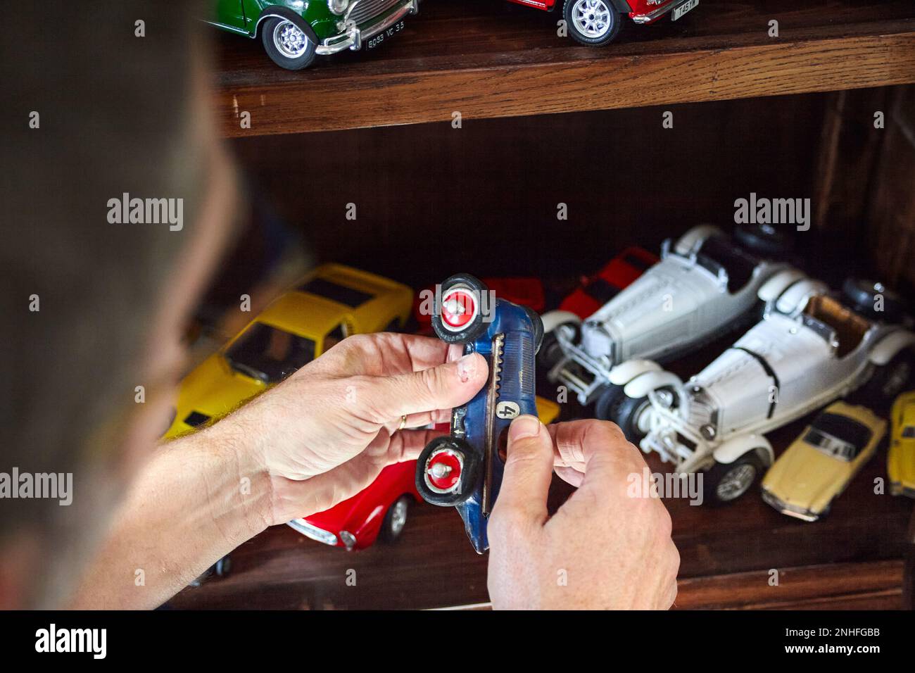 A man admiring one of his many vintage miniature cars Stock Photo
