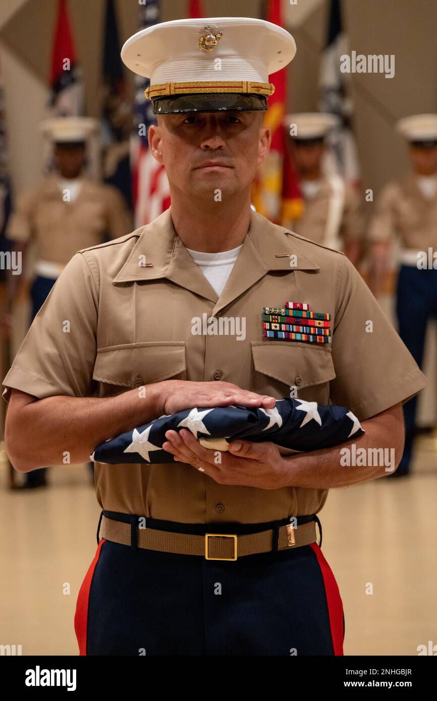 U.S. Marine Corps Chief Warrant Officer Fabian Marin, the Installation Personnel Administration Center director, Headquarters and Support Battalion, Marine Corps Installations Pacific, holds the U.S. flag during his retirement ceremony on Camp Foster, Okinawa, Japan, July 29, 2022.  Marin honorably retired after 27 years enlisting in the Marine Corps in 1995. Throughout his career, he served two deployments in the Republic of Iraq, and two director positions at Marine Corps Air Station Iwakuni and Marine Corps Baes Camp Foster. Stock Photo