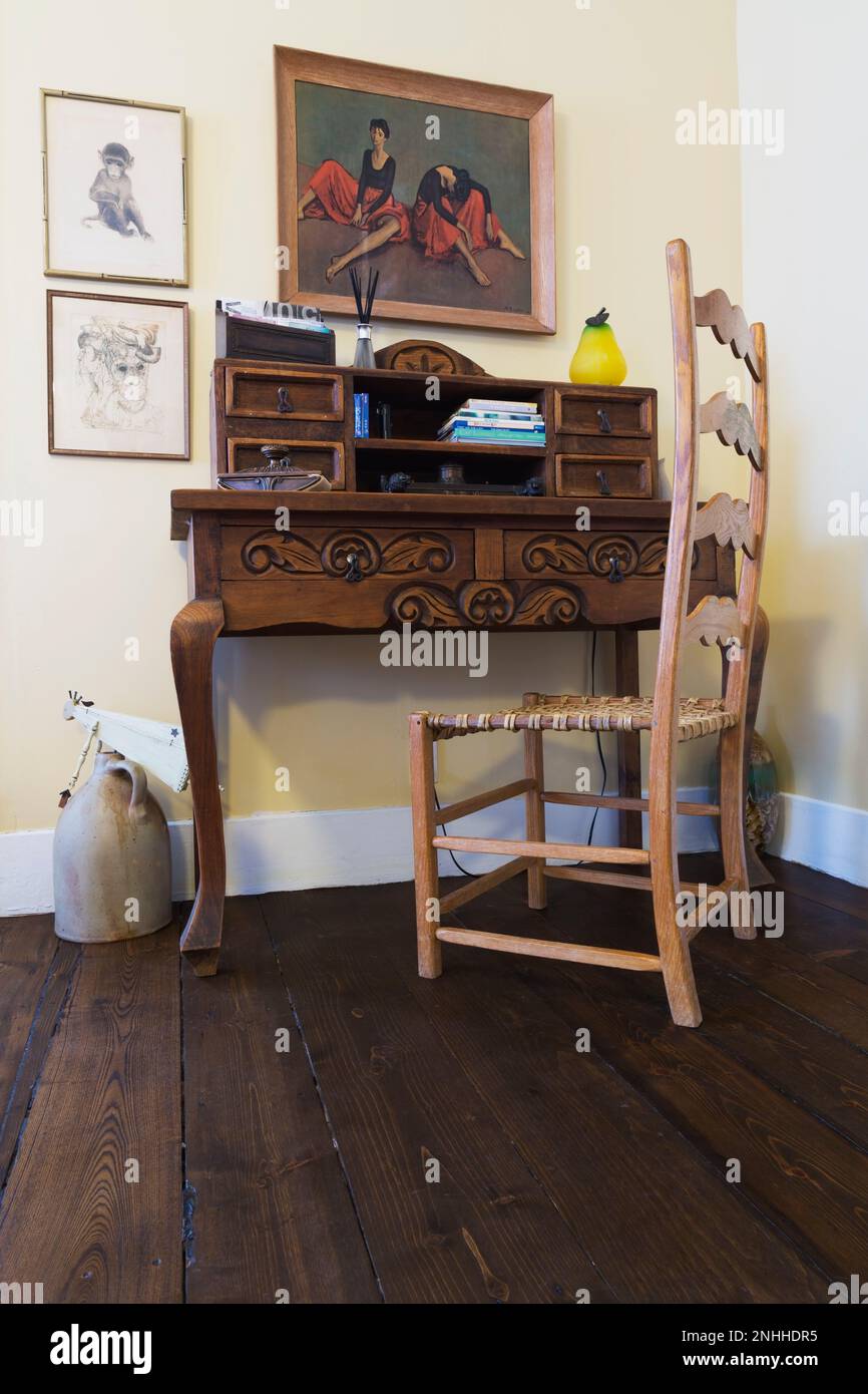 Antique wooden secretary desk woven seat high back chair in living room