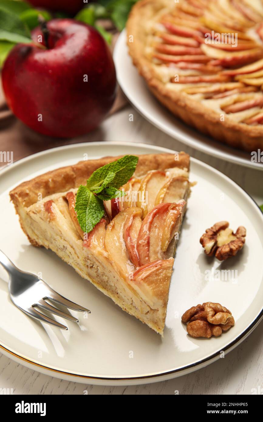 Slice of delicious apple pie on white wooden table Stock Photo