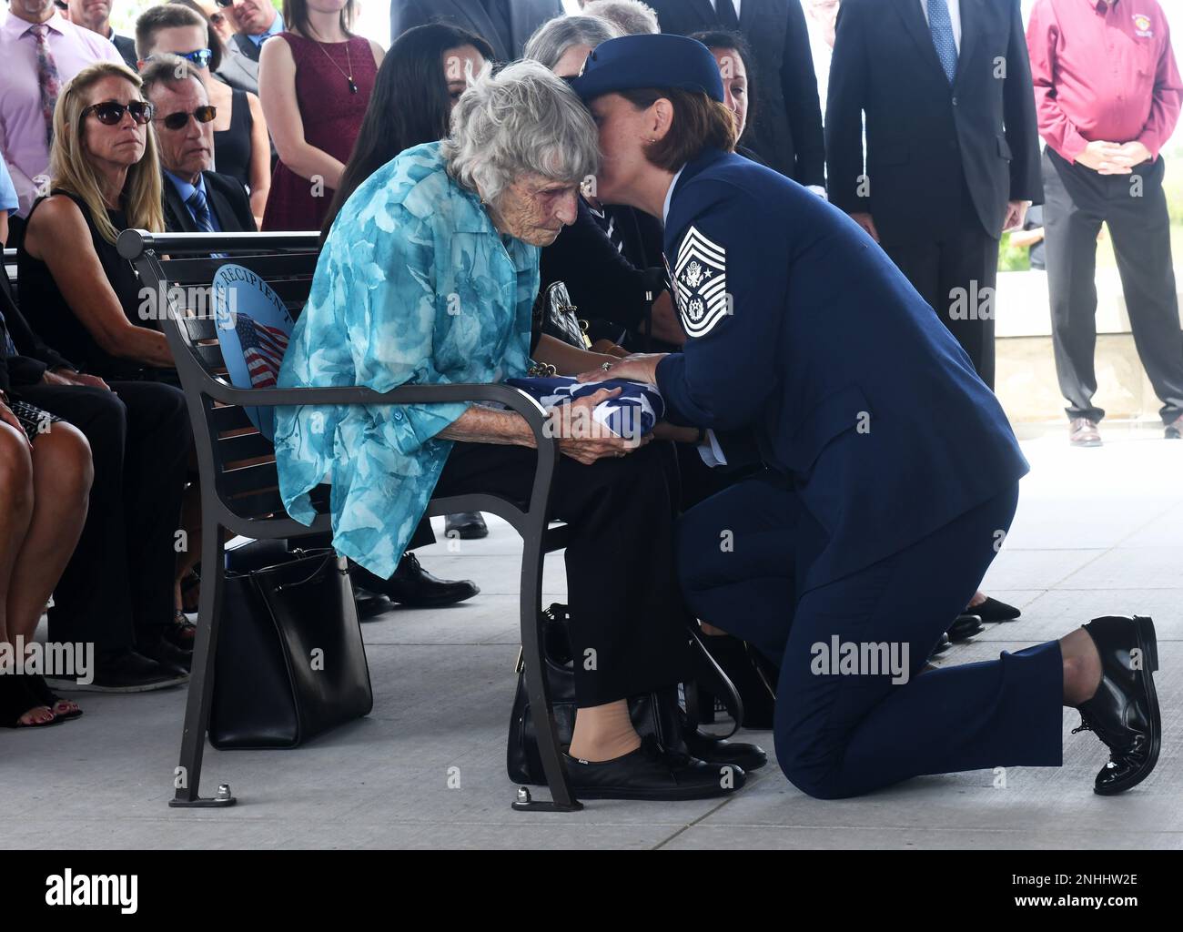 Kathleen McCoy receives a folded United States flag presented to her by