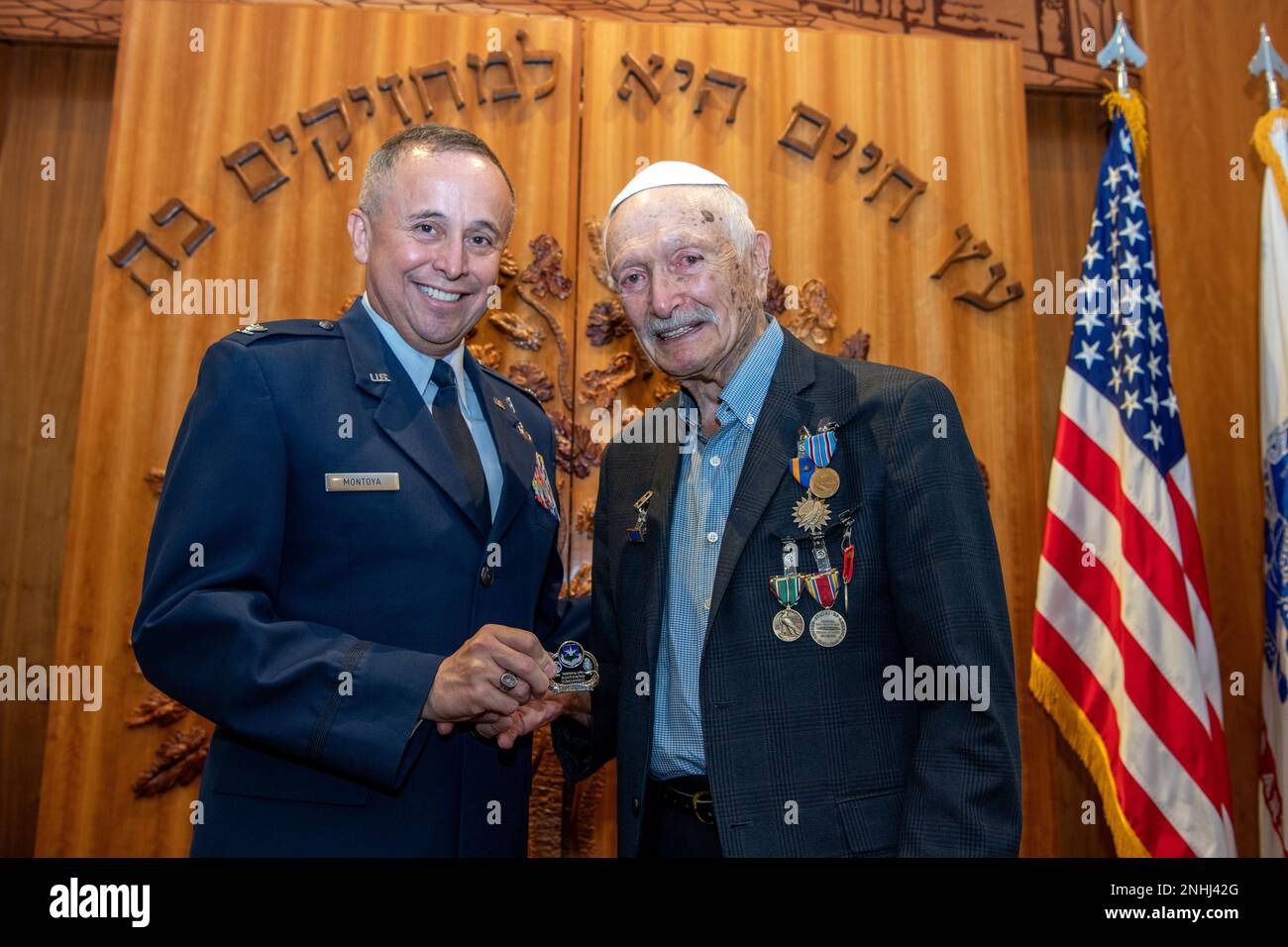 U.S. Air Force Chaplain (Col.) Charles Montoya, Jr. (left), presents a Joint Base San Antonio Senior Chaplain coin to Army Air Corps 1st Lt. Gerald Teldon, retired, after his awards ceremony for his honorable service as a pilot on July 29, 2022, at the Chabad Center for Jewish Life and Learning, San Antonio, Texas. Teldon, born in the Bronx, N.Y., in 1924, joined the military in 1944. He completed 62 missions during WWII and the Korean War. Lt. Col. Andrew Stein, 502nd Operations Support Squadron commander, was the presiding officer. The awards presented to Teldon are as follows: the Air Medal Stock Photo
