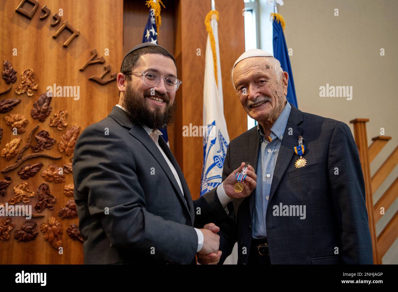 U.S. Army Air Corps 1st Lt. Gerald Teldon (right), retired, receives his award from his grandson, Rabbi Mendel Teldon, for his honorable service as a pilot on July 29, 2022, at the Chabad Center for Jewish Life and Learning, San Antonio, Texas. Teldon, born in Bronx, N.Y., in 1924, joined the military in 1944. He completed 62 missions during WWII and the Korean War. Lt. Col. Andrew Stein, 502nd Operations Support Squadron commander, was the presiding officers. The awards presented to Teldon are as follows: the Air Medal; American Campaign Medal; European – African – Middle Eastern Campaign Med Stock Photo