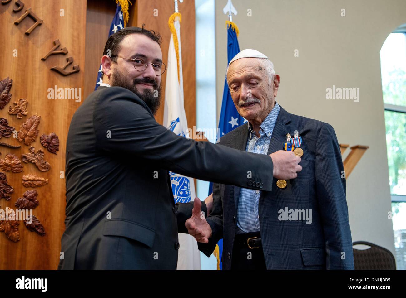 U.S. Army Air Corps 1st Lt. Gerald Teldon (right), retired, receives his award from his grandson, Rabbi Zalman Teldon, for his honorable service as a pilot on July 29, 2022, at the Chabad Center for Jewish Life and Learning, San Antonio, Texas. Teldon, born in Bronx, N.Y., in 1924, joined the military in 1944. He completed 62 missions during WWII and the Korean War. Lt. Col. Andrew Stein, 502nd Operations Support Squadron commander, was the presiding officers. The awards presented to Teldon are as follows: the Air Medal; American Campaign Medal; European – African – Middle Eastern Campaign Med Stock Photo