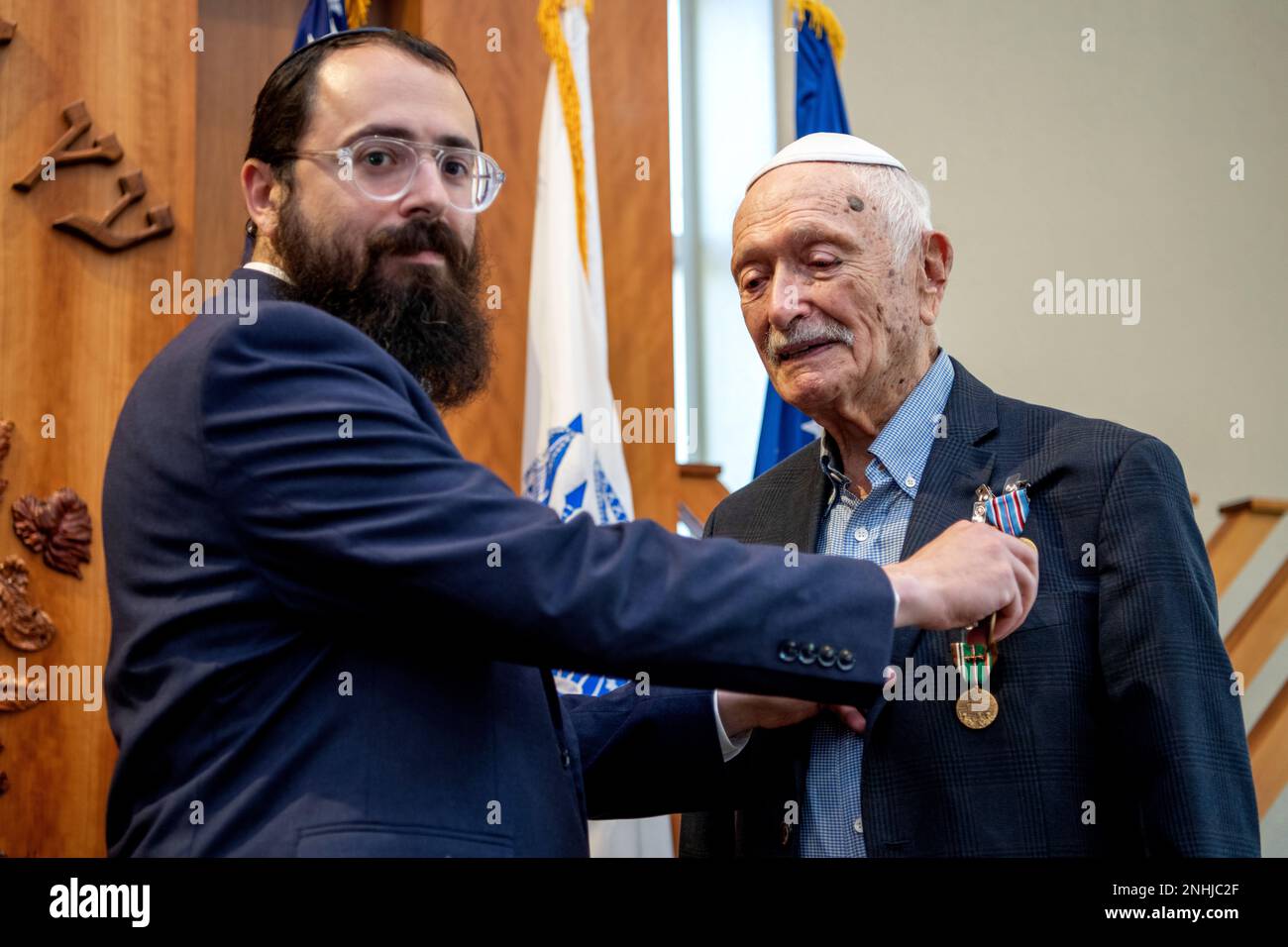 U.S. Army Air Corps 1st Lt. Gerald Teldon (right), retired, receives his award from his grandson, Rabbi Levi Teldon, for his honorable service as a pilot on July 29, 2022, at the Chabad Center for Jewish Life and Learning, San Antonio, Texas. Teldon, born in Bronx, N.Y., in 1924, joined the military in 1944. He completed 62 missions during WWII and the Korean War. Lt. Col. Andrew Stein, 502nd Operations Support Squadron commander, was the presiding officers. The awards presented to Teldon are as follows: the Air Medal; American Campaign Medal; European – African – Middle Eastern Campaign Medal Stock Photo
