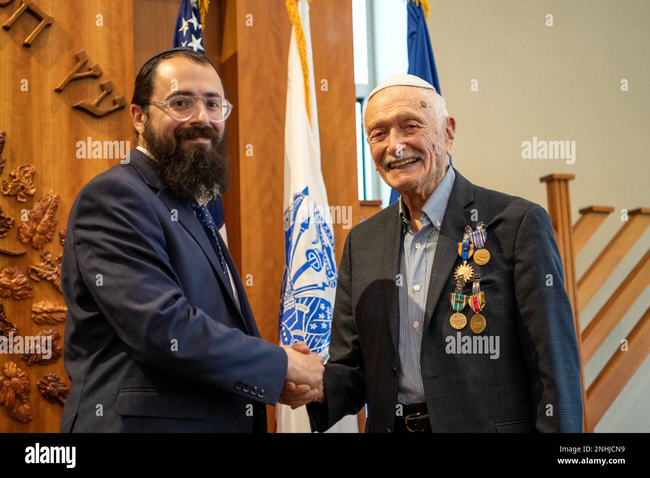 U.S. Army Air Corps 1st Lt. Gerald Teldon (right), retired, receives his award from his grandson, Rabbi Levi Teldon, for his honorable service as a pilot on July 29, 2022, at the Chabad Center for Jewish Life and Learning, San Antonio, Texas. Teldon, born in Bronx, N.Y., in 1924, joined the military in 1944. He completed 62 missions during WWII and the Korean War. Lt. Col. Andrew Stein, 502nd Operations Support Squadron commander, was the presiding officers. The awards presented to Teldon are as follows: the Air Medal; American Campaign Medal; European – African – Middle Eastern Campaign Medal Stock Photo
