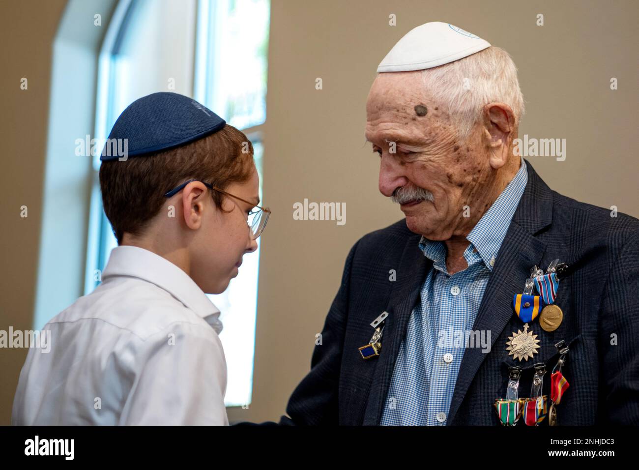 U.S. Army Air Corps 1st Lt. Gerald Teldon (right), retired, receives his ribbons from his great grandson, Menachem Mendel Teldon, for his honorable service as a pilot on July 29, 2022, at the Chabad Center for Jewish Life and Learning, San Antonio, Texas. Teldon, born in Bronx, N.Y., in 1924, joined the military in 1944. He completed 62 missions during WWII and the Korean War. Lt. Col. Andrew Stein, 502nd Operations Support Squadron commander, was the presiding officers. The awards presented to Teldon are as follows: the Air Medal; American Campaign Medal; European – African – Middle Eastern C Stock Photo
