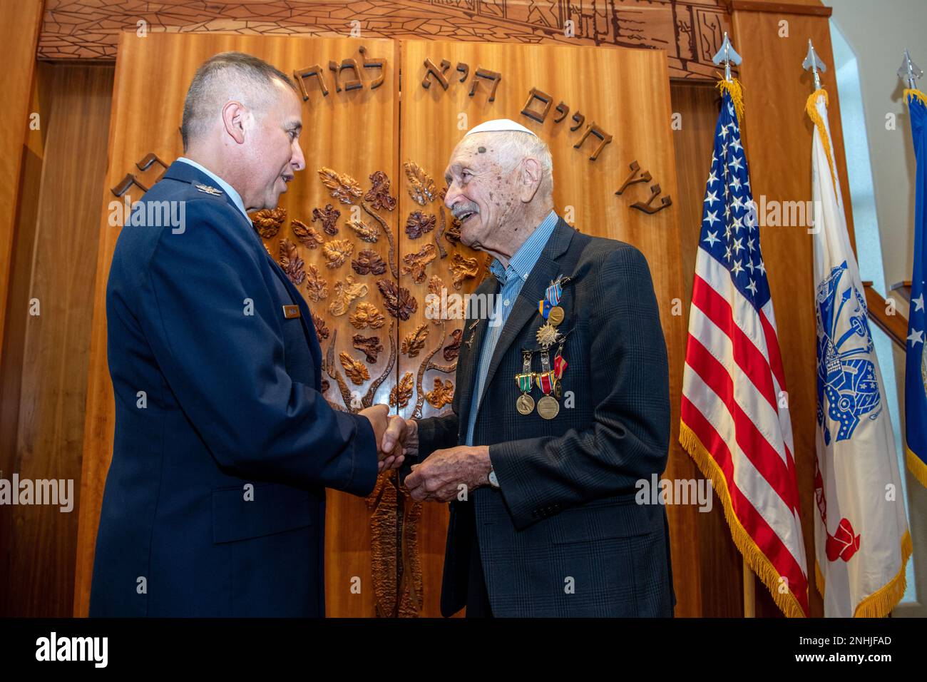 U.S. Air Force Col. Charles Montoya, Jr. (left), presents a coin to U.S. Army Air Corps 1st Lt. Gerald Teldon, retired, after his awards ceremony for his honorable service as a pilot on July 29, 2022, at the Chabad Center for Jewish Life and Learning, San Antonio, Texas. Teldon, born in Bronx, N.Y., in 1924, joined the military in 1944. He completed 62 missions during WWII and the Korean War. Lt. Col. Andrew Stein, 502nd Operations Support Squadron commander, was the presiding officers. The awards presented to Teldon are as follows: the Air Medal; American Campaign Medal; European – African – Stock Photo