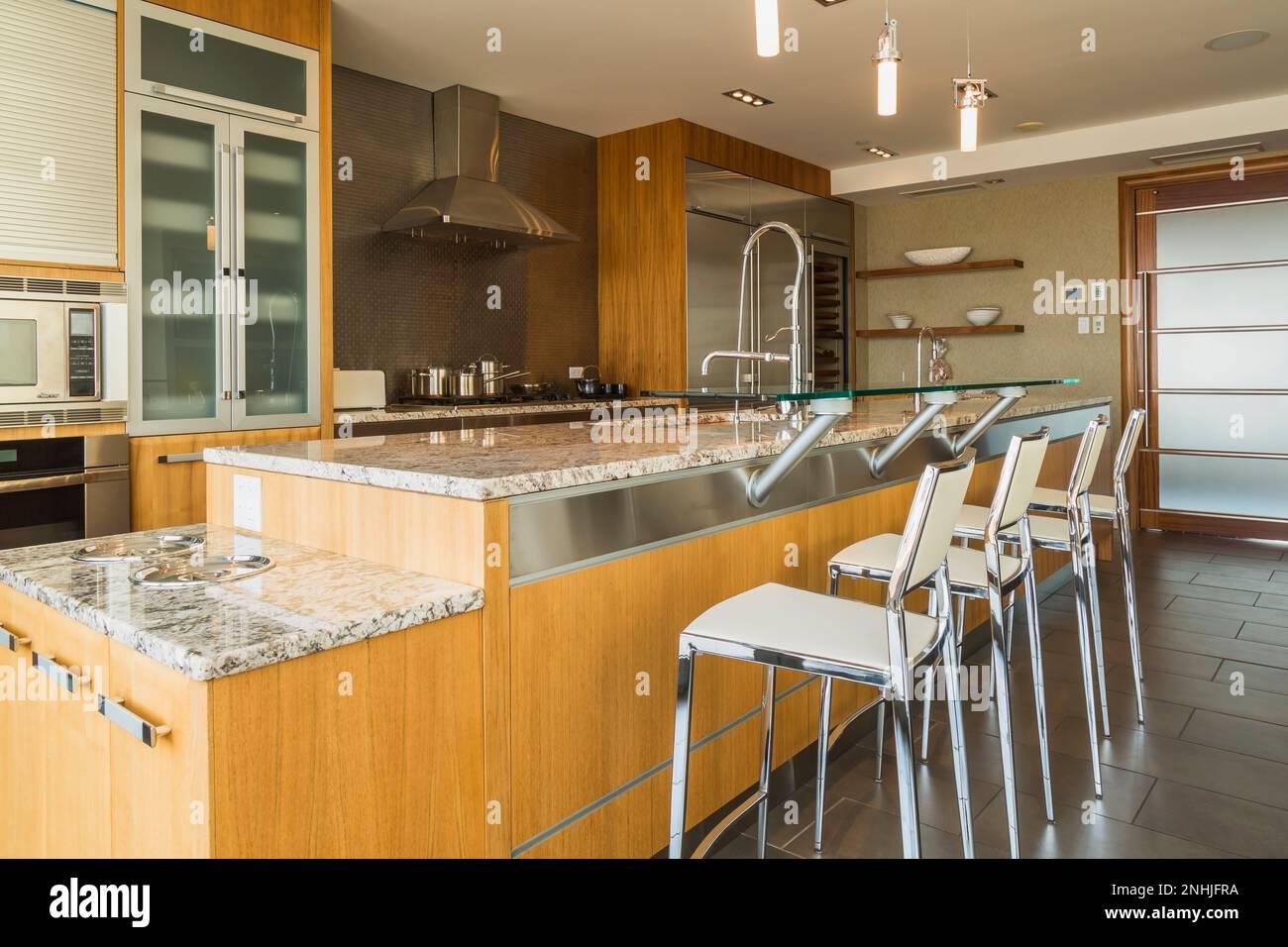 Kitchen with white stone countertops, solid wood cabinets, and vintage tile  on the walls Stock Photo - Alamy