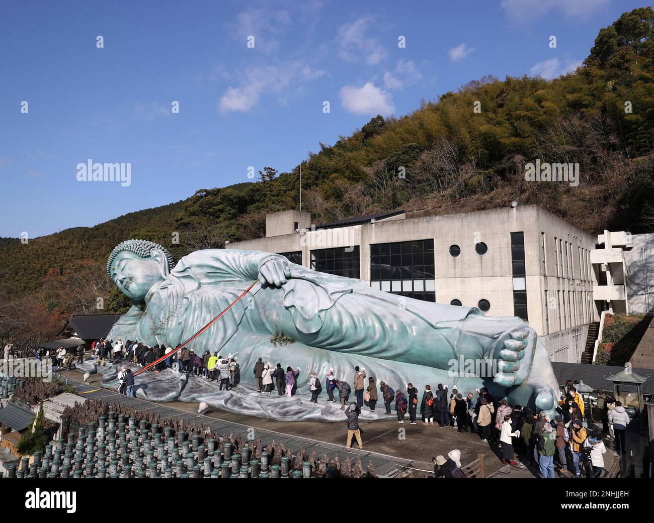 Approximately 200 Buddhist priests and believers clean a reclining