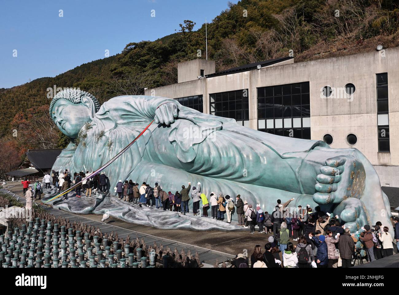 Approximately 200 Buddhist priests and believers clean a reclining