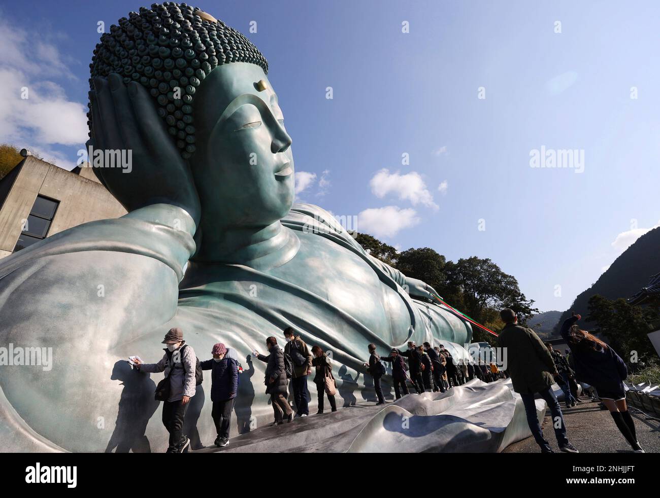 Approximately 200 Buddhist priests and believers clean a reclining