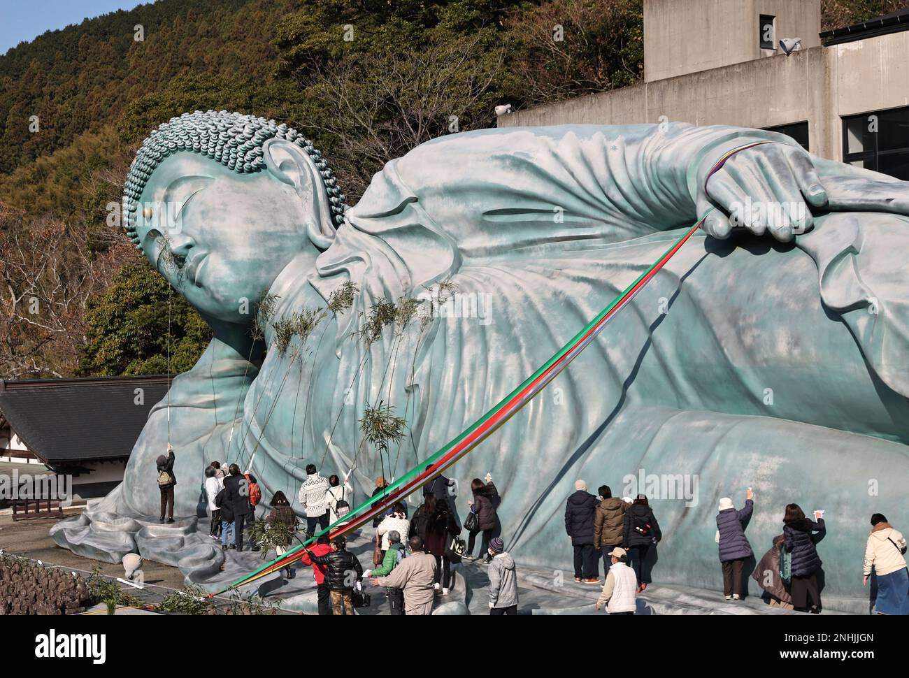 Approximately 200 Buddhist priests and believers clean a reclining