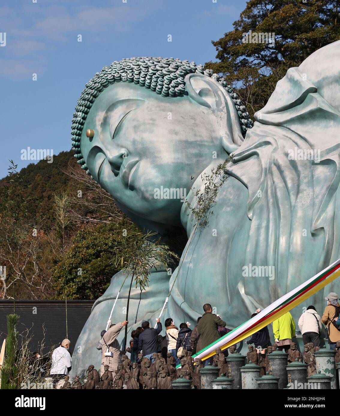 Approximately 200 Buddhist priests and believers clean a reclining