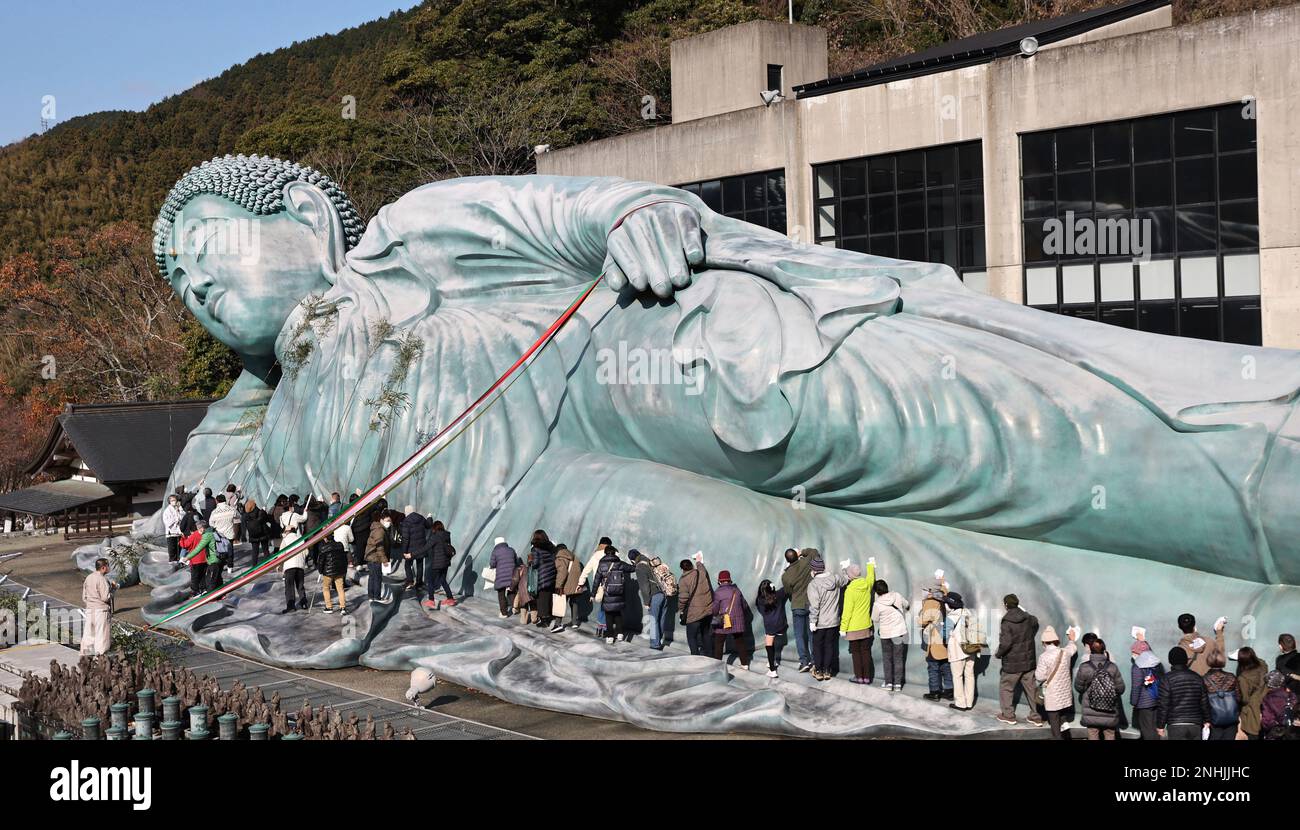 Approximately 200 Buddhist priests and believers clean a reclining