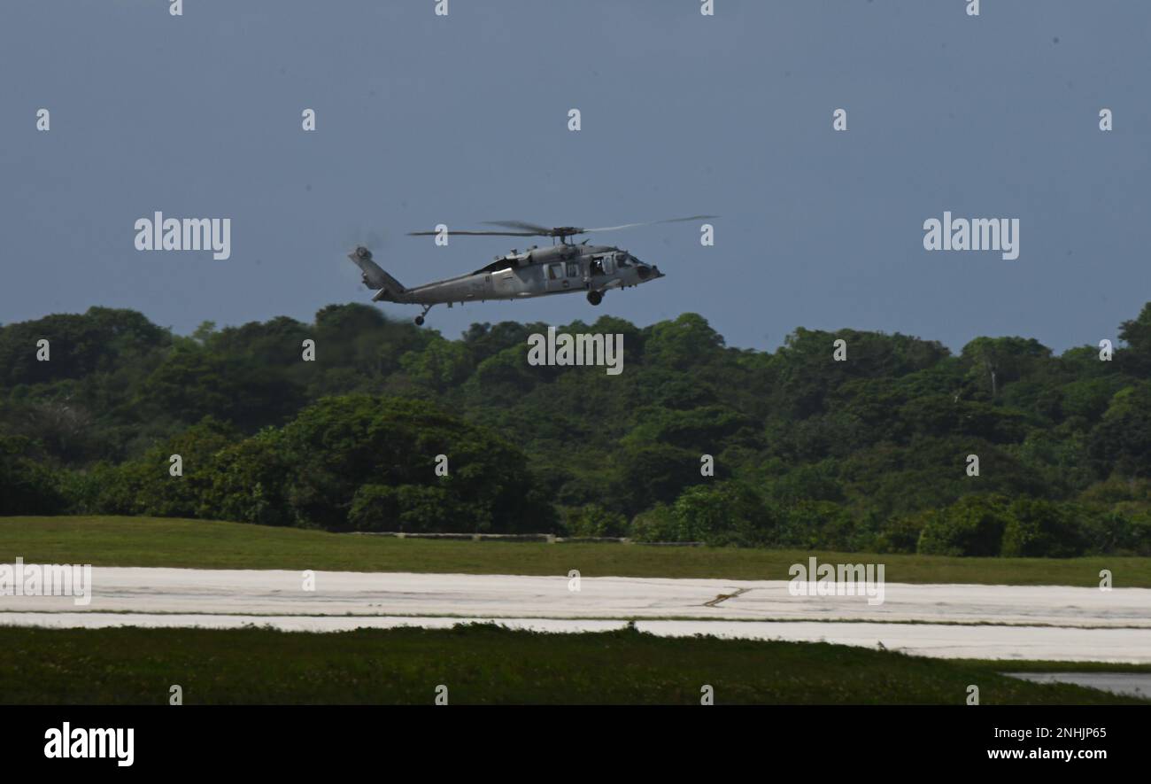 A U.S. Navy Sikorsky SH-60 Seahawk from the Helicopter Sea Combat Squadron 25 (HSC-25) hovers above an airfield at Andersen Air Force Base, Guam, during Cope North 2023, Feb. 9, 2023. Cope North allows each nation to hone vital readiness skills and enhance interoperability among multiple mission areas to include air superiority, interdiction, electronic warfare, tactical airlift, and aerial refueling capabilities. (U.S. Air National Guard photo by Senior Airman Christa Anderson) Stock Photo