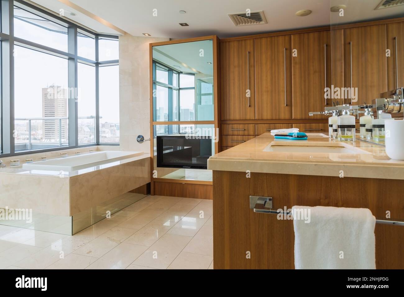 Exotic wood vanity, and white bathtub with marble casing plus