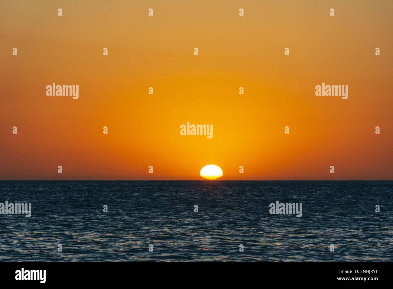 The Sun sets over the Ocean on a summer day Stock Photo
