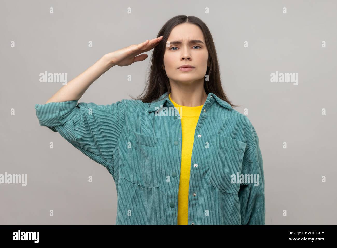 Yes sir. Serious smart young woman giving salute, listening carefully