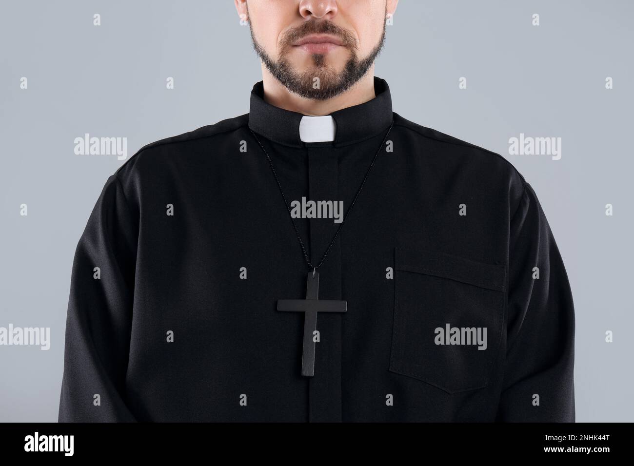Priest wearing cassock with clerical collar on grey background, closeup Stock Photo