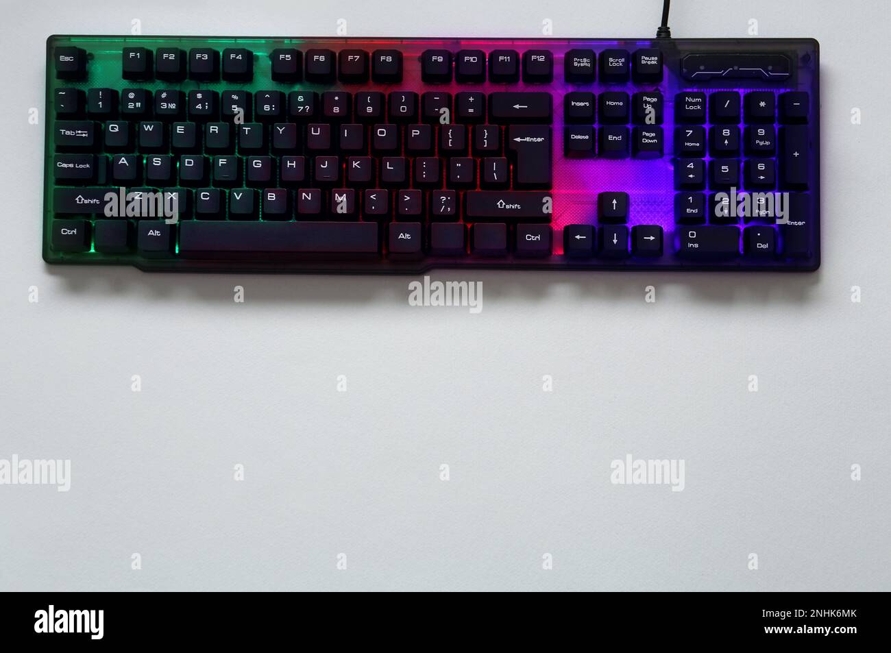 Modern RGB keyboard on grey background, top view. Space for text Stock