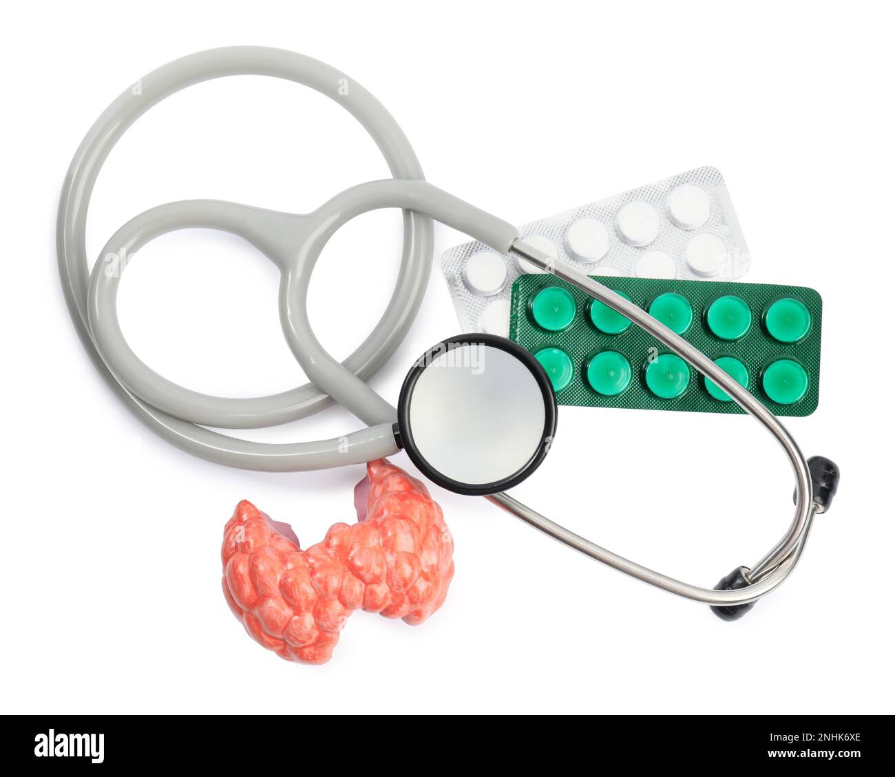 Plastic model of afflicted thyroid, pills and stethoscope on white background, top view Stock Photo