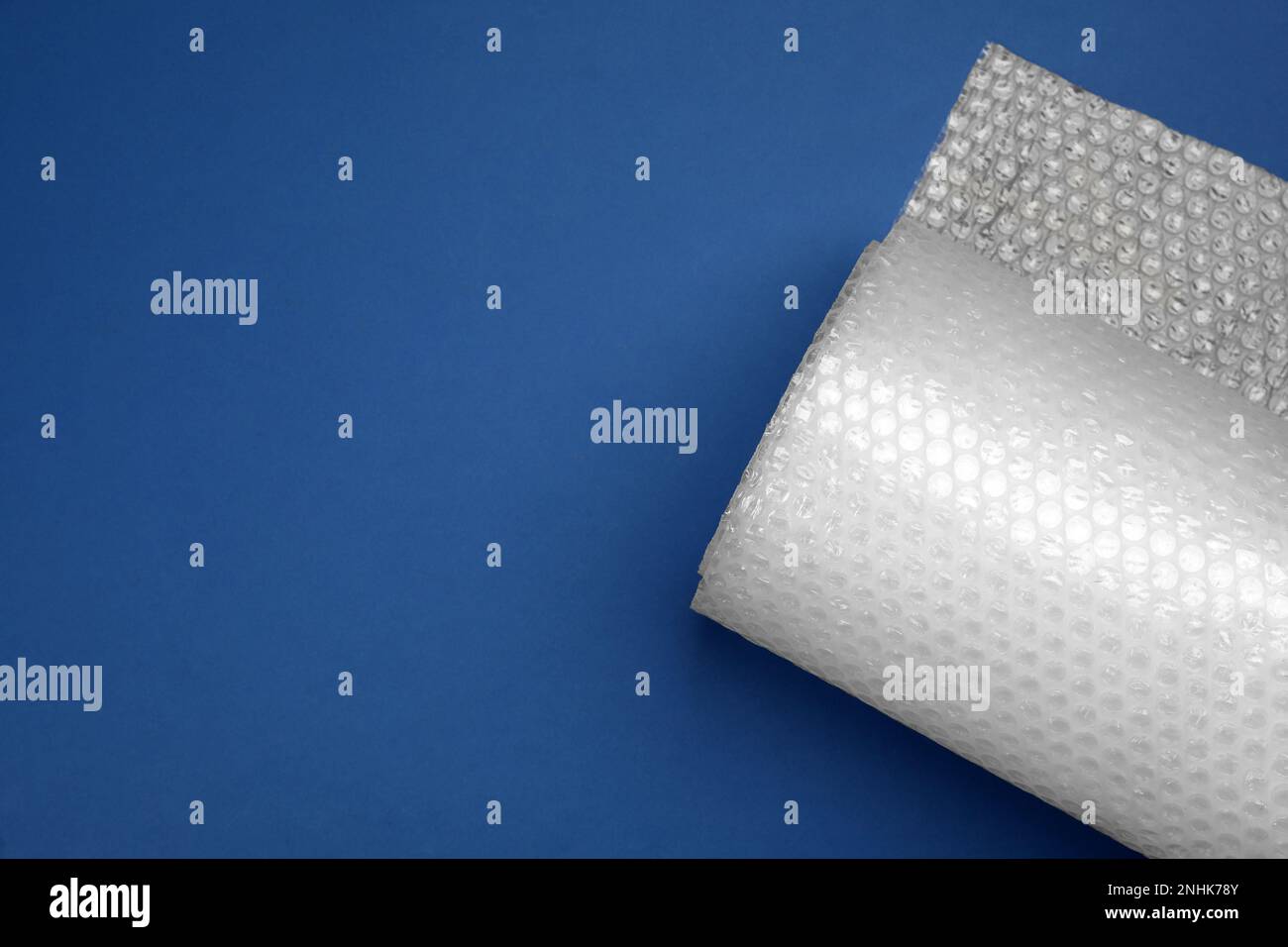 Bubble wrap roll on blue background, top view. Space for text Stock Photo