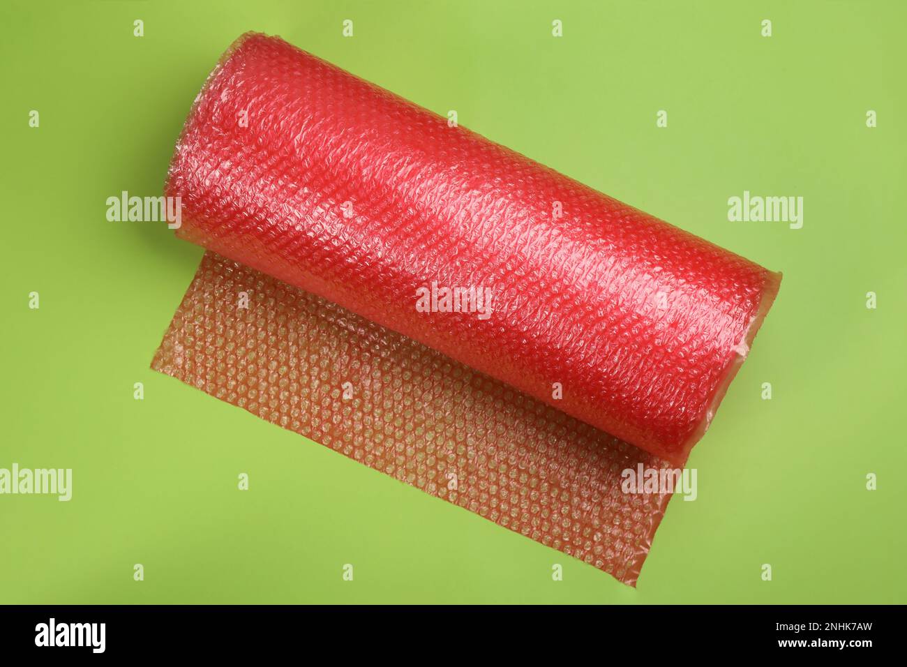 Bubble wrap roll on green background, top view Stock Photo