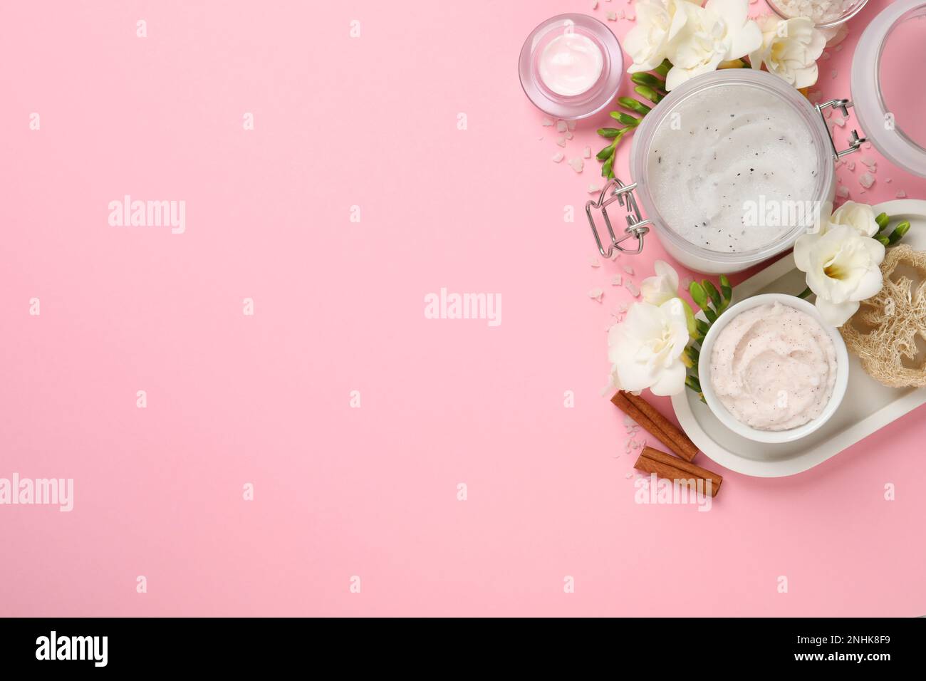 Flat lay composition with body scrubs on pink background, space for ...