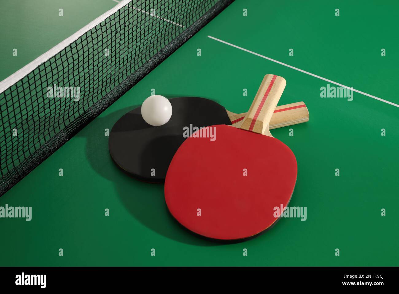 Rackets and ball near net on ping pong table Stock Photo