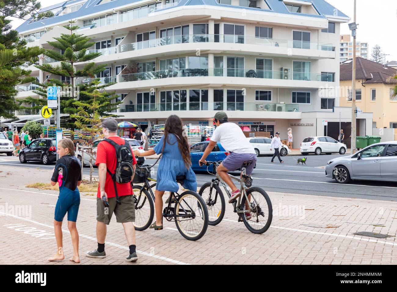 Manly Beach Australia, man and woman cycling bike riding along the