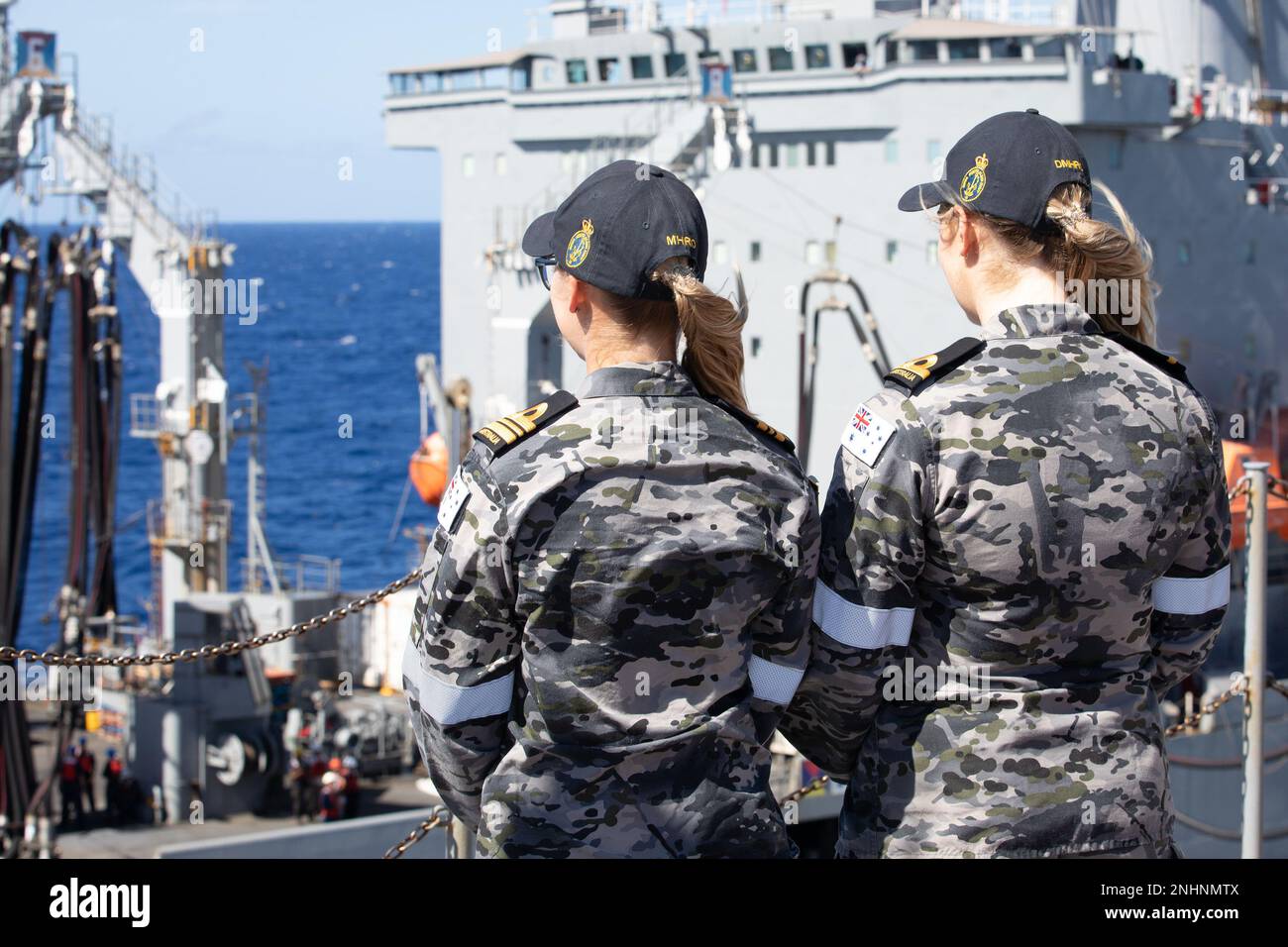 PACIFIC OCEAN (July 31, 2022) Royal Australian Navy Maritime Human Resources Officers Lt. Cmdr. Laura Watman and Sub-Lt. Katelyn Kirshaw observe a replenishment-at-sea conducted between U.S. Henry J. Kaiser-class fleet replenishment oiler USNS Henry J. Kaiser (T-AO 187) and Royal Australian Navy Canberra-class landing helicopter dock HMAS Canberra (L02) during Rim of the Pacific (RIMPAC) 2022. Twenty-six nations, 38 ships, three submarines, more than 170 aircraft and 25,000 personnel are participating in RIMPAC from June 29 to Aug. 4 in and around the Hawaiian Islands and Southern California. Stock Photo