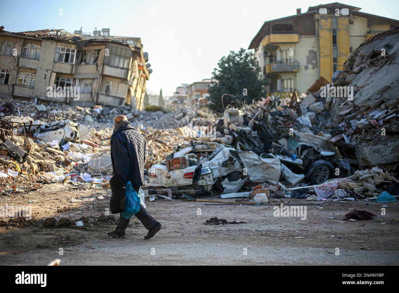 Hatay, Turkey. 14th Feb, 2023. A man walks past destroyed residentials