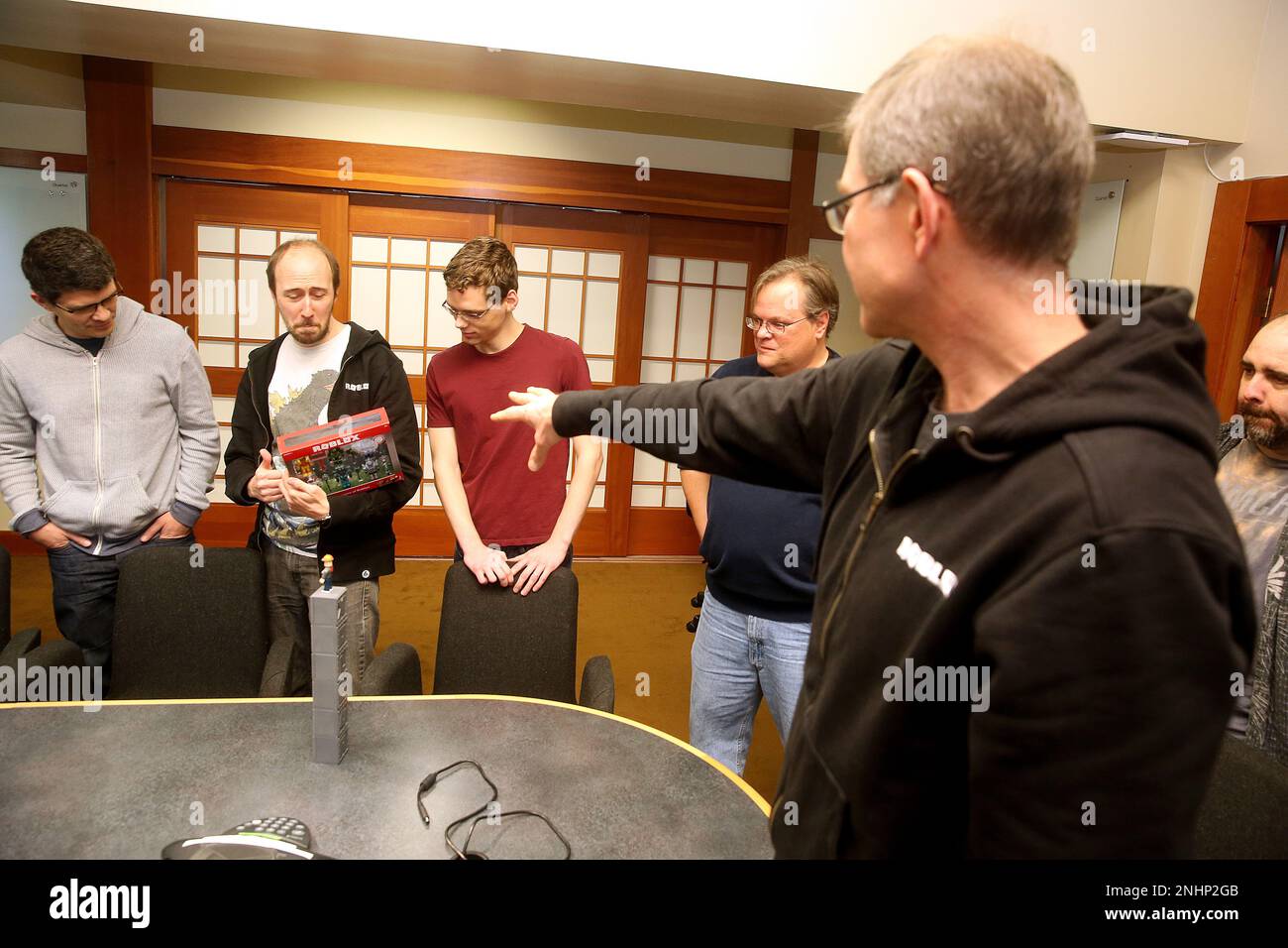 CEO David Baszucki (right) of Roblox gives the creative product team their  first view of the packaging for their new release of a line of physical  toys coming early next month, designed