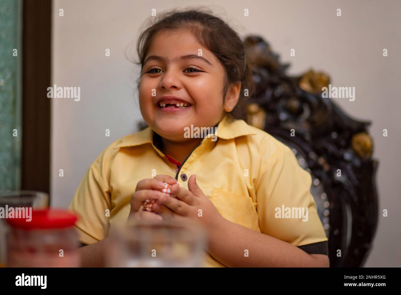 Close-up portrait of cheerful little girl while having breakfast at home Stock Photo