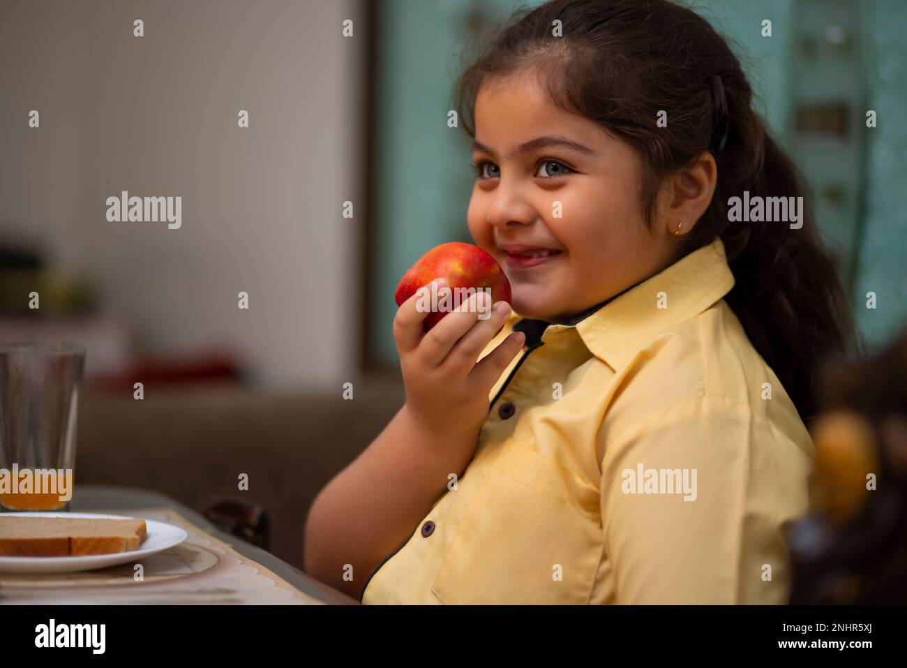 Indian girl eating apple hires stock photography and images Alamy