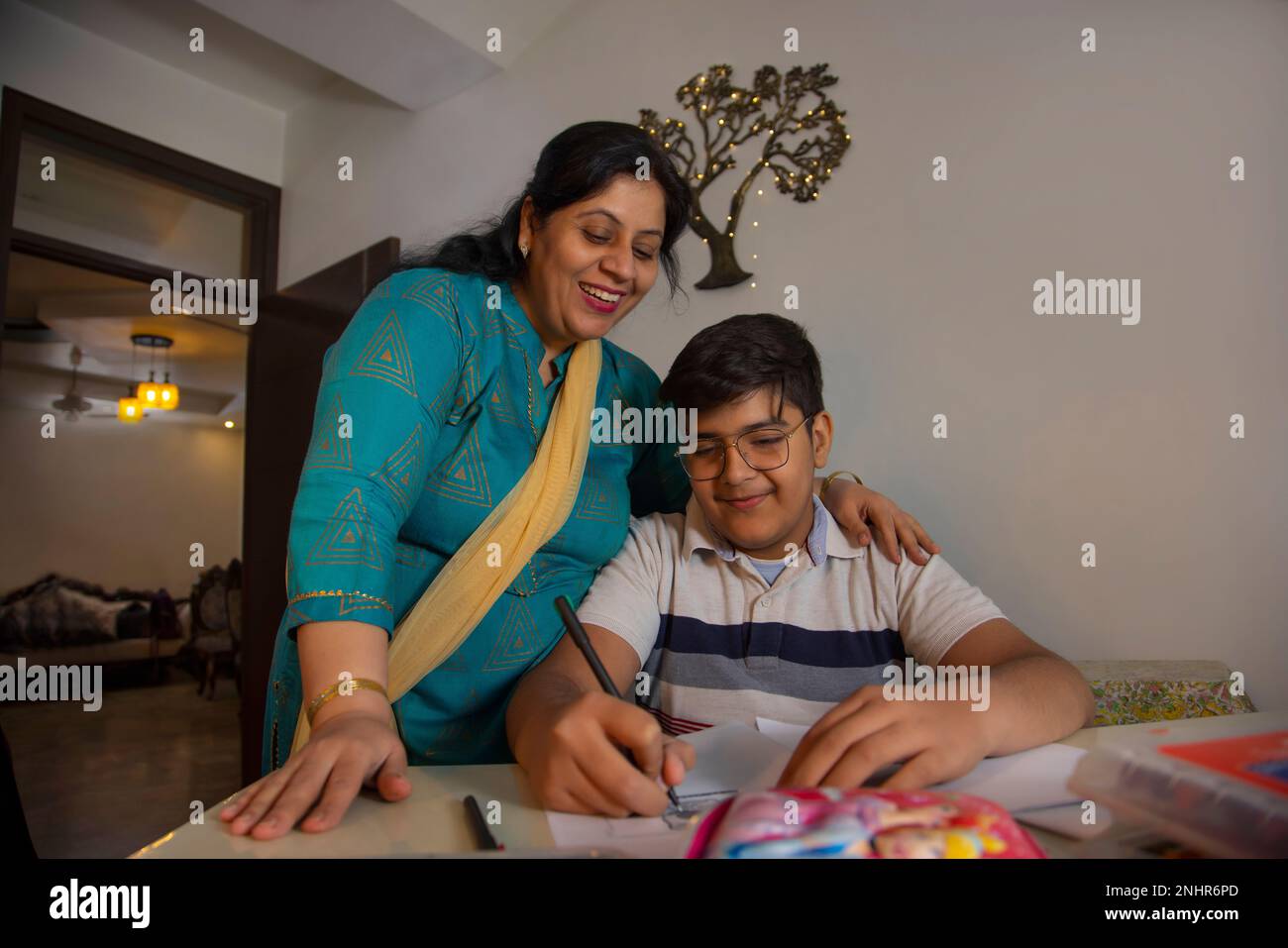 Mother helping her son with homework at home Stock Photo