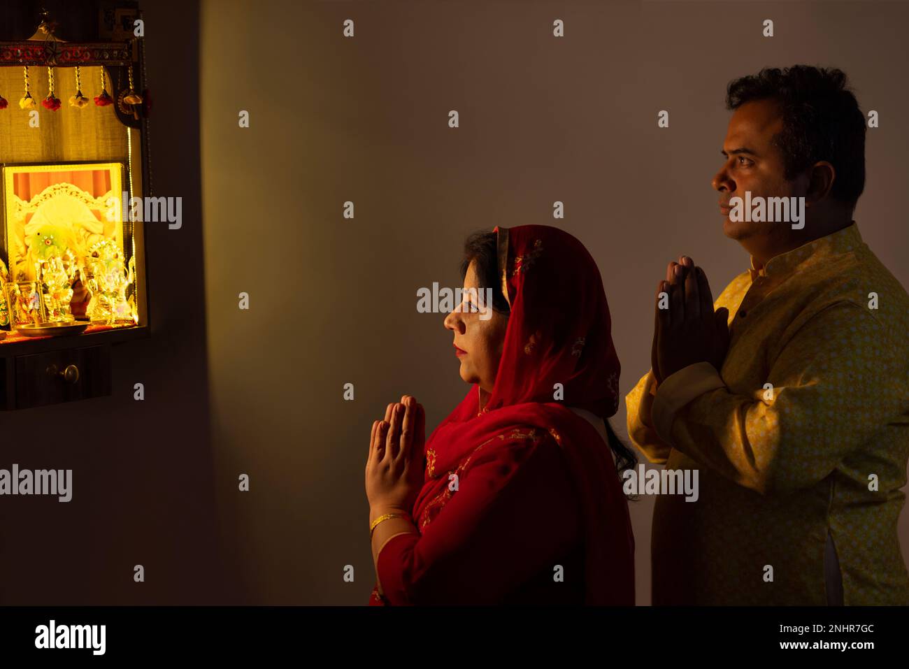 Portrait of couple praying to God together at home Stock Photo