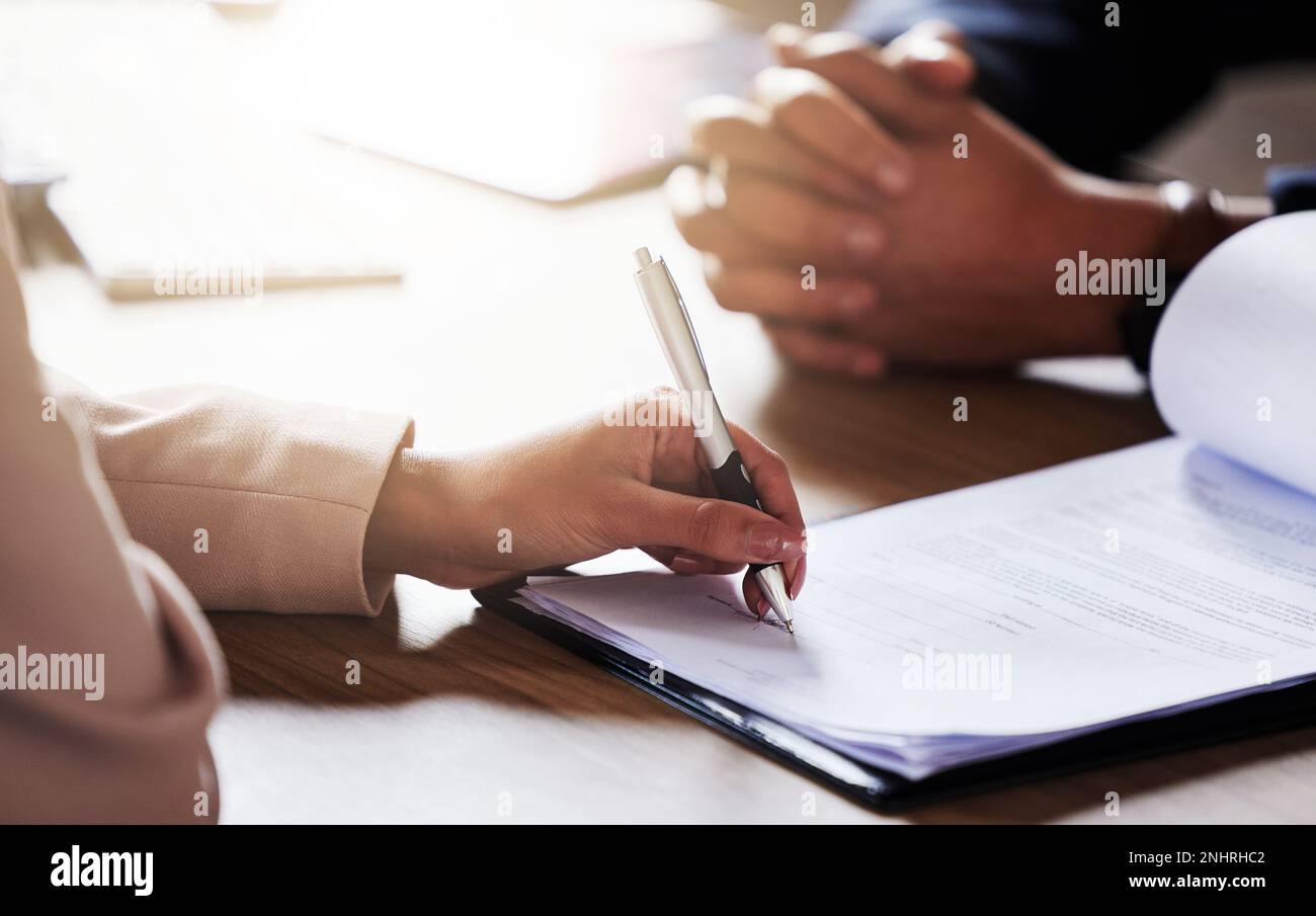Business people, hands and signing contract, form or application for hire, recruitment or policy on table. Hand of person writing or filling in Stock Photo