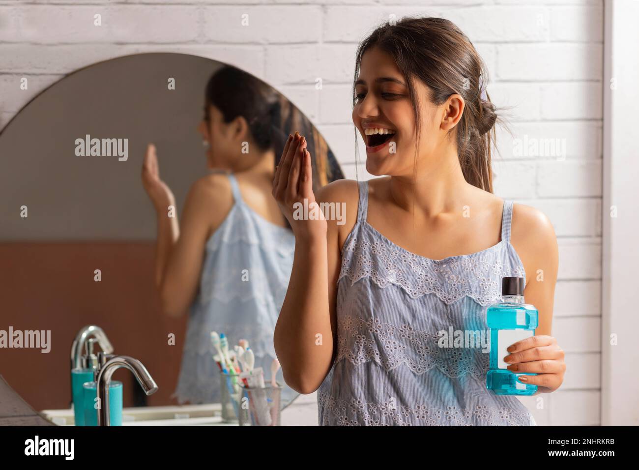 Young woman smelling her breath after using mouthwash Stock Photo Alamy