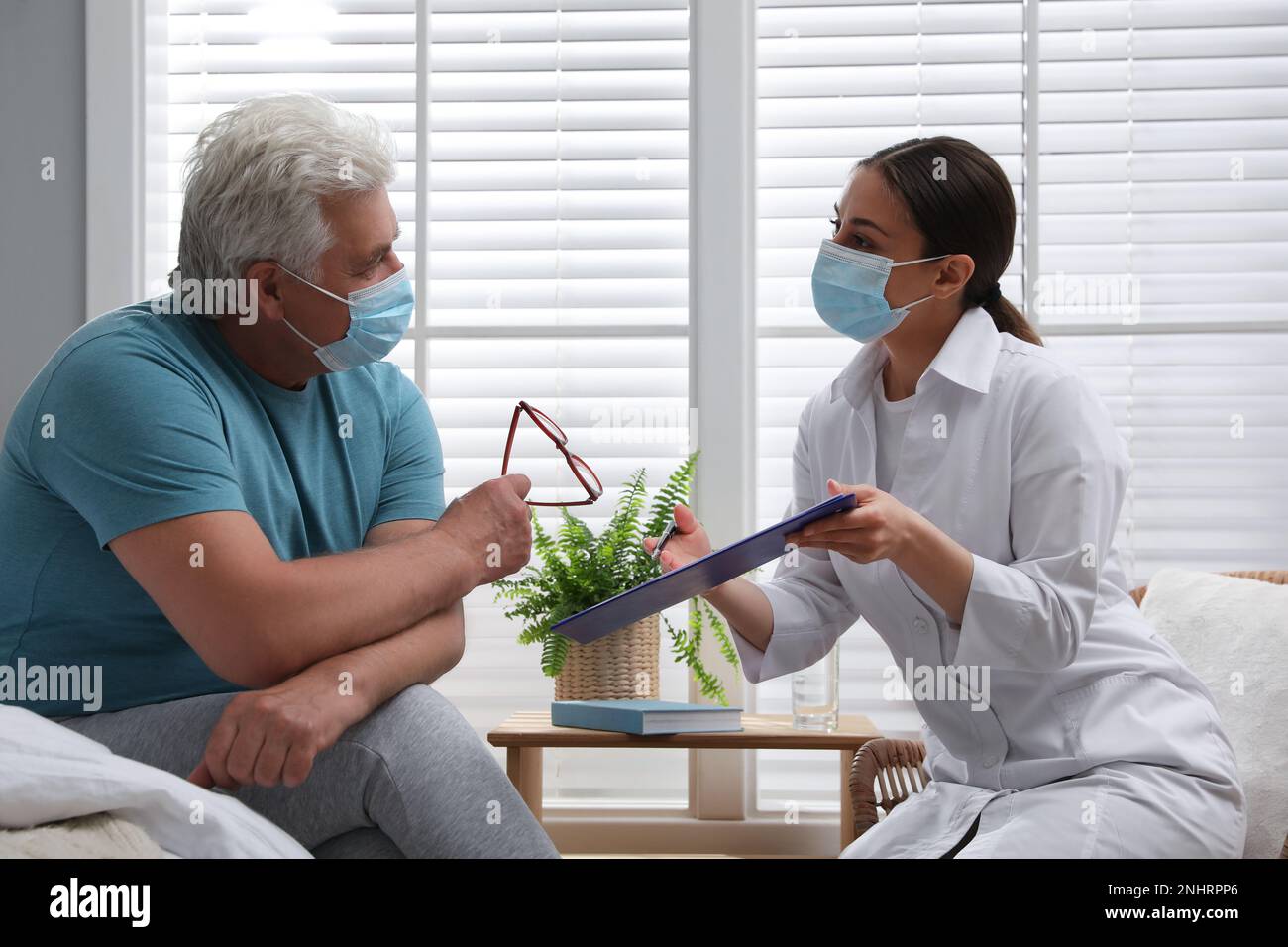 Doctor in mask talking senior hi-res stock photography and images - Alamy