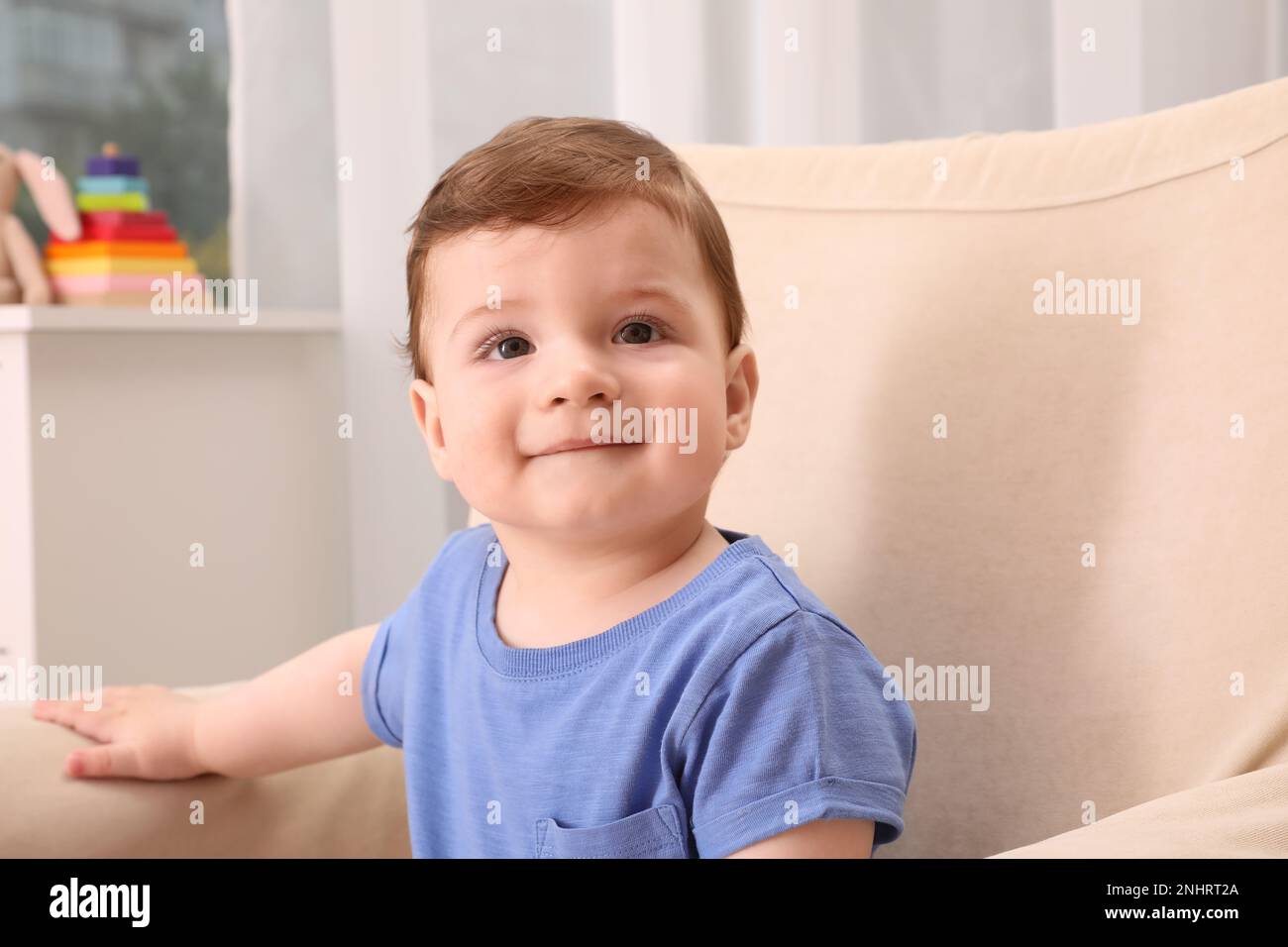 Cute baby boy sitting in armchair at home Stock Photo Alamy