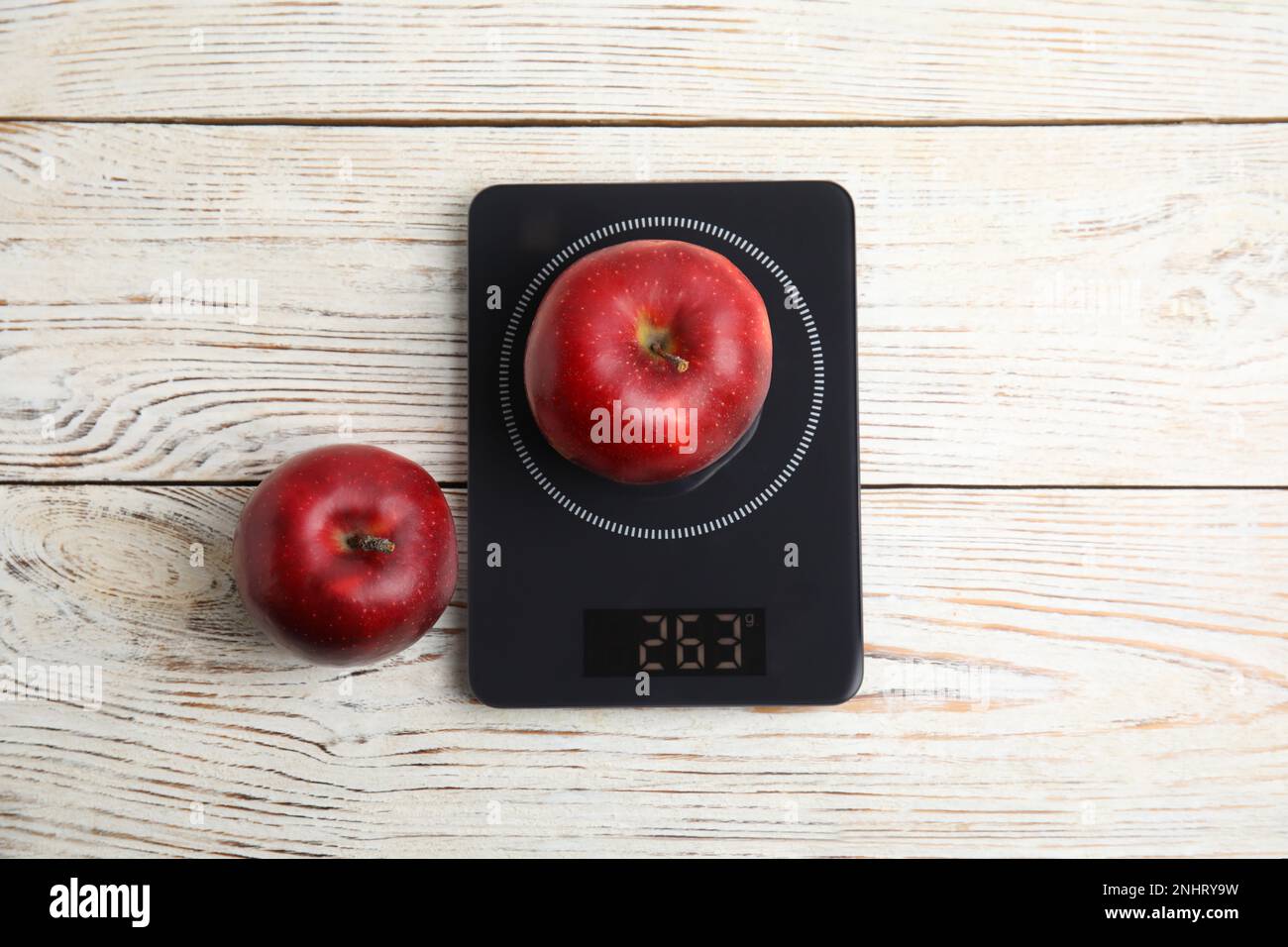 https://c8.alamy.com/comp/2NHRY9W/ripe-red-apples-and-electronic-scales-on-white-wooden-table-flat-lay-2NHRY9W.jpg