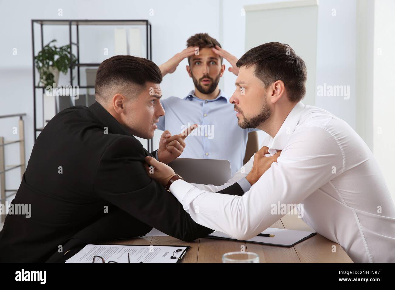 Emotional colleagues fighting in office. Workplace conflict Stock Photo
