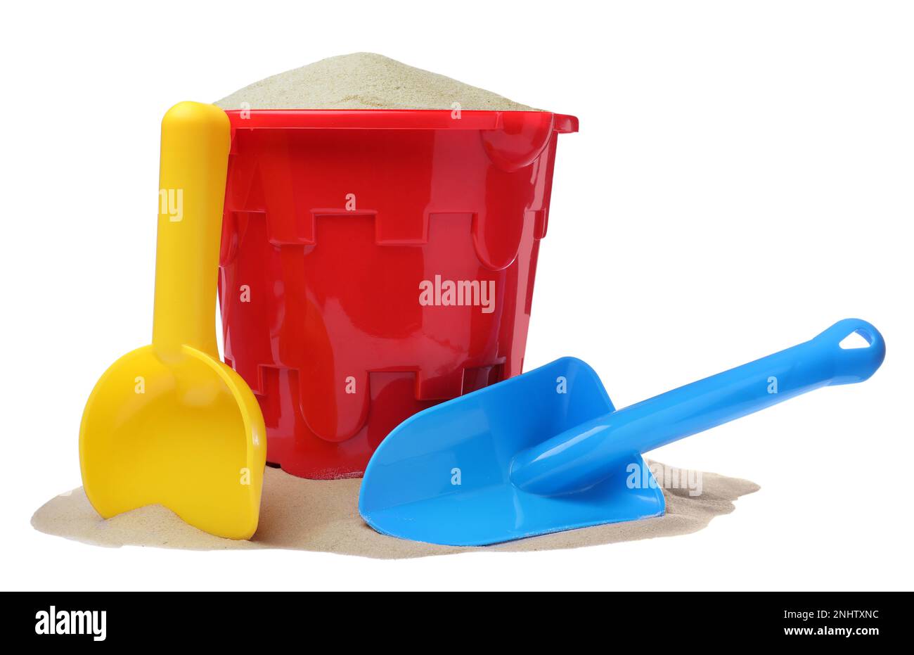 Plastic toy bucket with colorful shovels and sand on white background