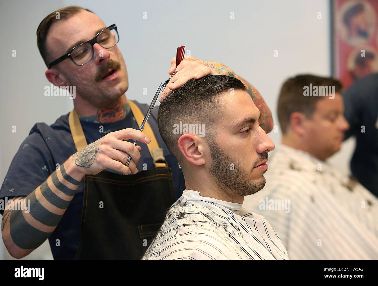 Barber Harley Maxwell cuts the hair of JP A. Lefebvre at Blades Co